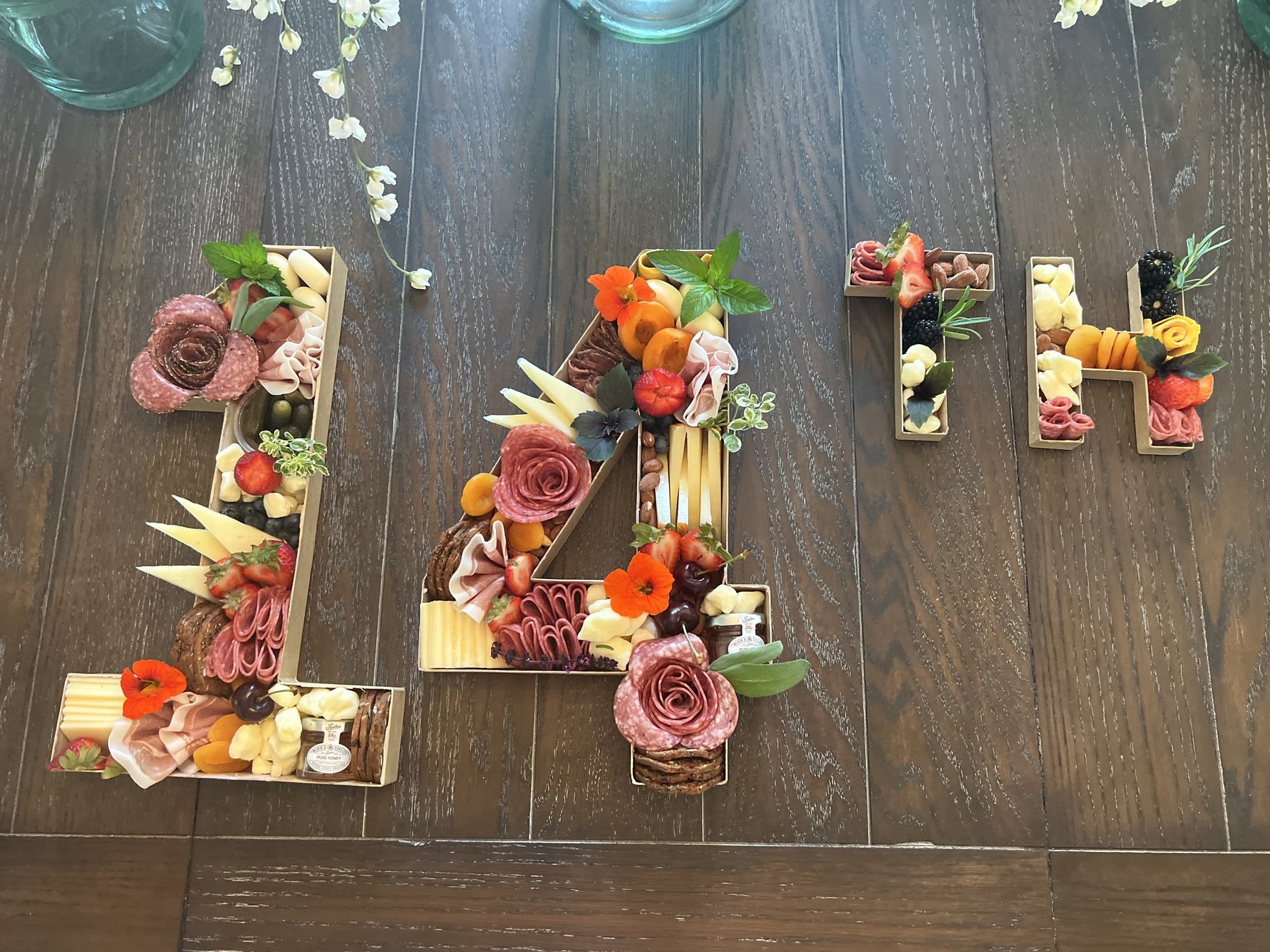 Charcuterie arranged in letter-shaped serving trays