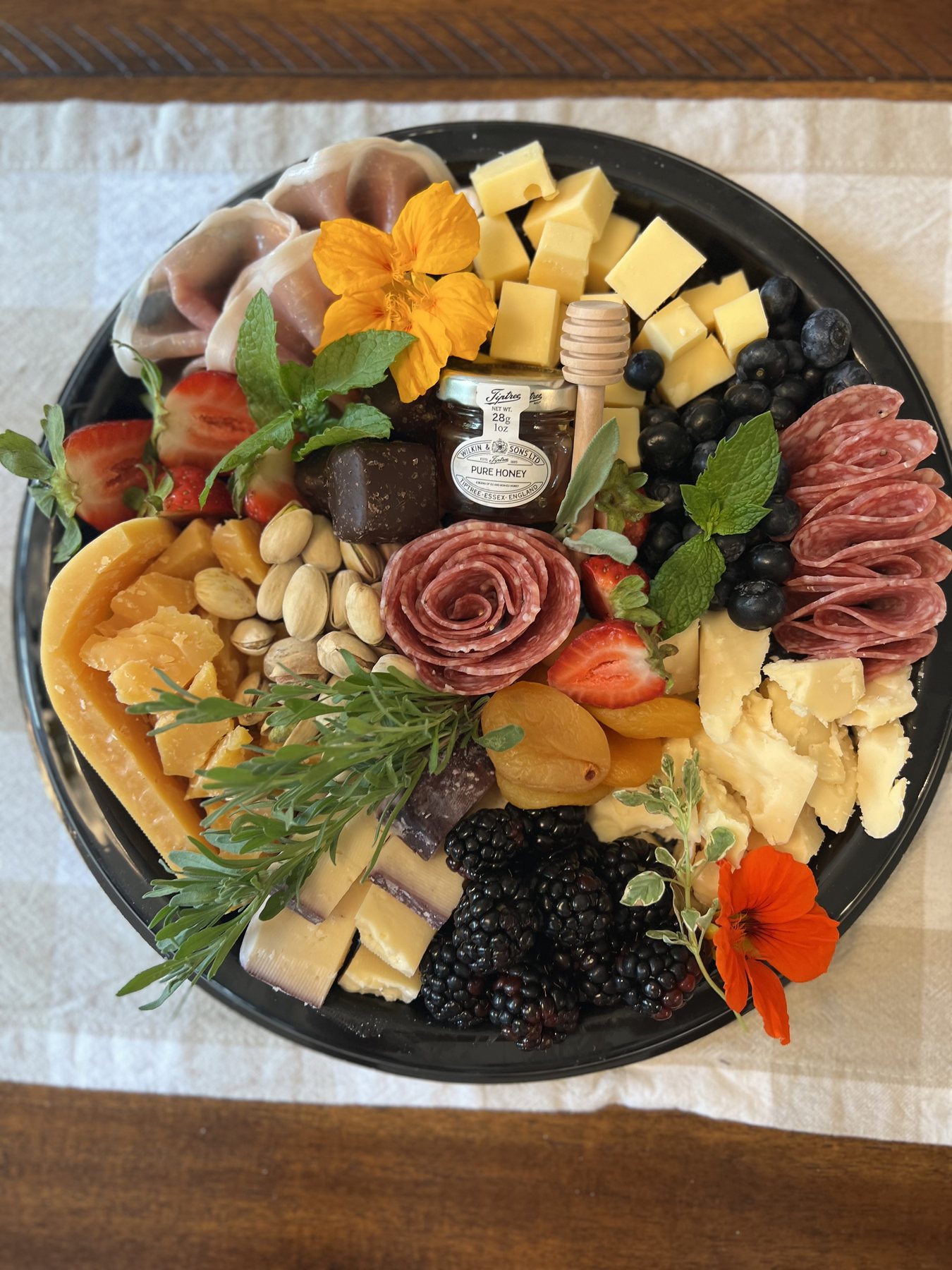 Signature charcuterie board with cheeses, cured meats, fruit, nuts, and accompaniments